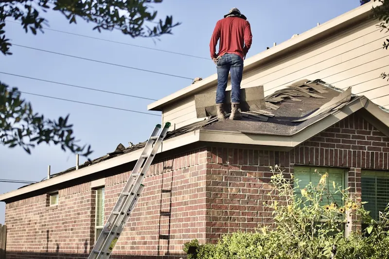 Professional roofer working on a residential roof in Hel-Mel